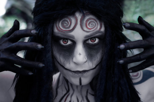 Art photo of a mystic faun with spiral patterns on his forehead and red eyes.