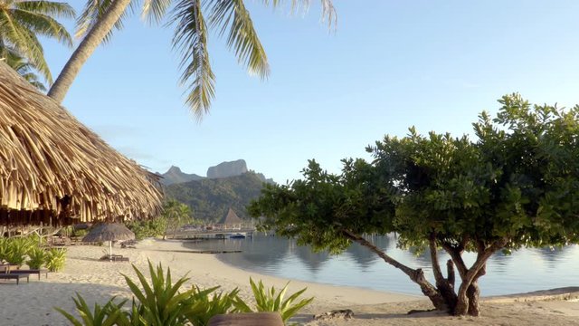 Seamless Loop video: Bora Bora beach vacation paradise island with overwater bungalows resort hotel and beach hut in coral reef lagoon ocean and beach. Mount Otemanu, Bora Bora, Tahiti, South Pacific.
