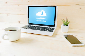 Cloud Downloading files on a laptop with coffee and smartphone home office digital workspace cozy...