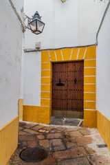 Narrow street with colorful gate in the center of Cordoba, Spain