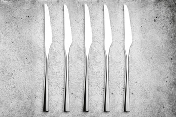 Cutlery. Knives on a light concrete background. Flat lay, top view.