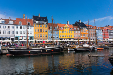 Fototapeta na wymiar Summertime in the fantastic city of Copenhagen. Iconic Nyhavn with its colorful houses and old boats