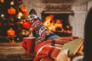 Christmas socks with woman legs on wooden board of free space for your decoration and blurred...