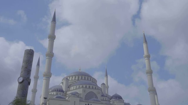 Atik Valide Mosque on warm day as clouds travel past historic building 