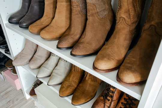 Collection of shoes sorted in shoe rack, brown colors, organized interior in a closed