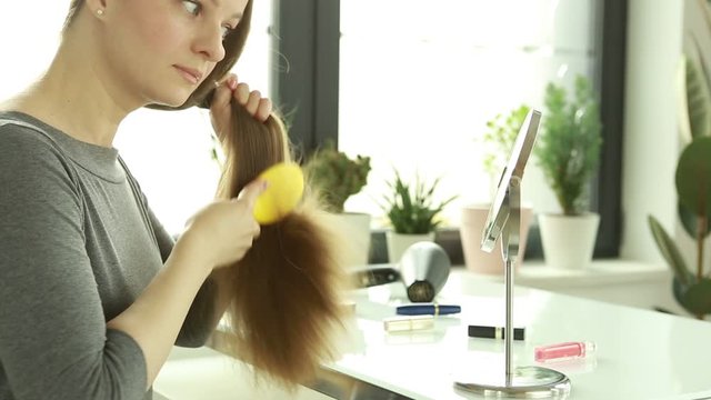 Hair loss. A woman is combing her hair.