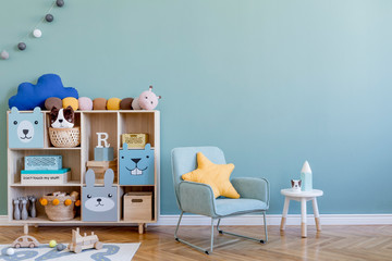 Scandinavian nursery room with wooden cabinet, mint armchair, natural teddy bears and plush animal...