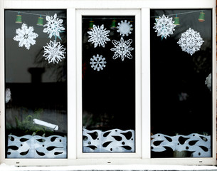 Homemade Christmas and New Year paper decoration on the window. handmade Christmas and New Year decorations on the window. New year and Christmas concept, handmade decorative paper on the window. 