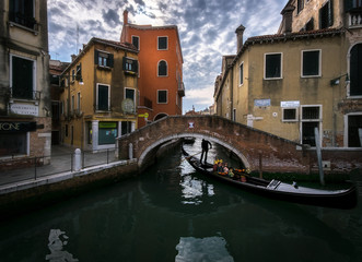 The sharp turns of the Venetian canals. A day in the life of gondoliers. Reflections in sea water. Venice. Italy.