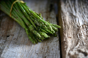 Fresh green asparagus on wooden table background. Healthy lifestyle concept.
