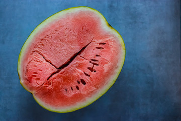 Fototapeta na wymiar Half ripe watermelon on a gray background. Soft focus. Top view.
