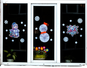 Homemade Christmas and New Year paper decoration on the window. handmade Christmas and New Year decorations on the window. New year and Christmas concept, handmade decorative paper on the window. 