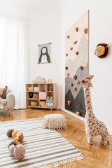 Stylish scandinavian interior design of childroom with gray sofa, modern climbing wall for kids,...