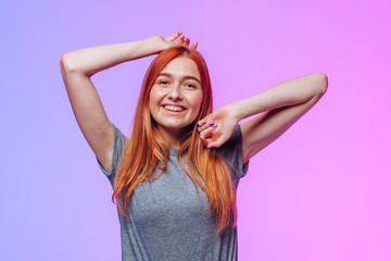 Fototapeta premium Redhead girl posing and smiling on pink blue background