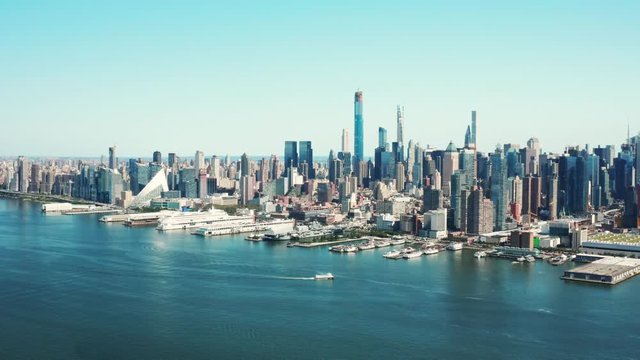 Aerial of Hudson Bay, high view of Manhattan cityscape, skyscrapers and landmark buildings, New York City at daytime, ships crossing cannel
