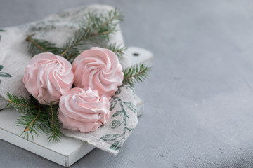 Obraz na płótnie Canvas Homemade pink marshmallow on the napkin with Christmas fir-tree branches