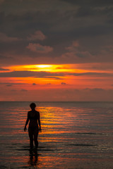 standing in the asian sea at sunset