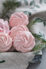 Obraz na płótnie Canvas Homemade pink marshmallow on the napkin with Christmas fir-tree branches
