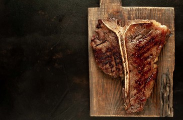  Grilled T-bone steak on a stone table. With copy space for your text.