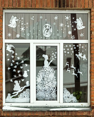Homemade Christmas and New Year paper decoration on the window. handmade Christmas and New Year decorations on the window. New year and Christmas concept, handmade decorative paper on the window. 