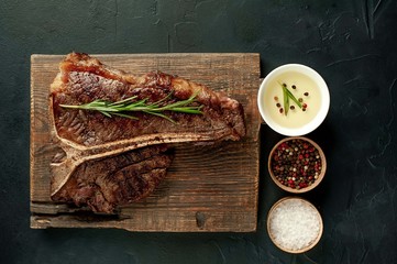 Grilled T-bone steak on a stone table. With rosemary and spices.  © александр таланцев