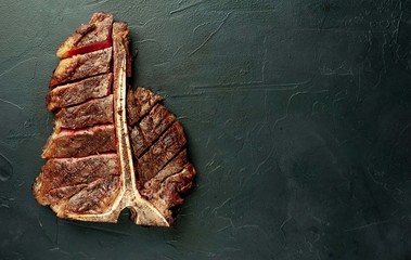  Grilled T-bone steak on a stone table. With copy space for your text.
