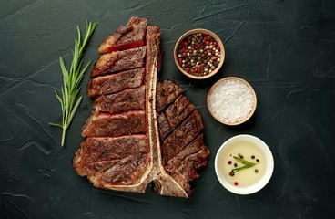 Grilled T-bone steak on a stone table. With rosemary and spices. 