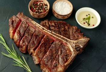 Grilled T-bone steak on a stone table. With rosemary and spices. 