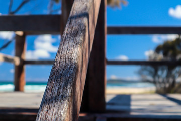 Fototapeta premium Close-up of a wooden handrail in a clear day at the beach