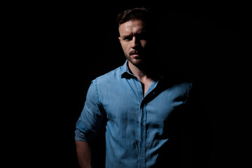 casual mysterious  man standing in the shadows