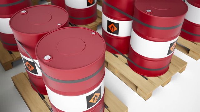 Red and white metal barrels with a flammable symbol on body are arranged in row on wooden pallets. Petrol tanks on white background. Closeup, camera truck movement, seamless looping 60 fps animation.
