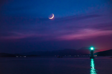 Lighthouse and crescent moon - summer night background