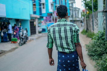 young man walking in street and carrying bag