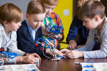 Positive children play and assemble the constructor in the children's room.