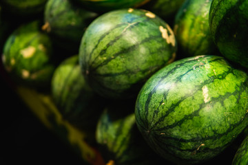 Ripe and sweet watermelons in the market. Close up. A lot of large ripe green striped watermelons. Organic farmer market, store.