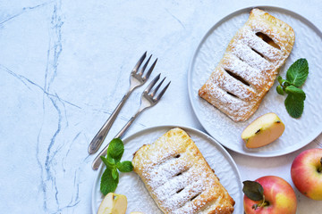 Puffs with apples and cinnamon in a plate on the kitchen table. View from above!