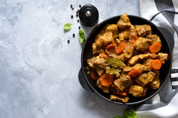 Stew with spices in a pan on a concrete background. View from above.