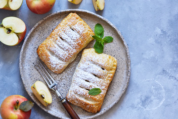 Puffs with apples and cinnamon in a plate on the kitchen table. View from above!