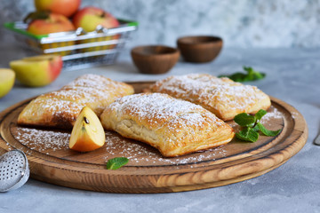 Puffs with apples and cinnamon in a plate on the kitchen table.