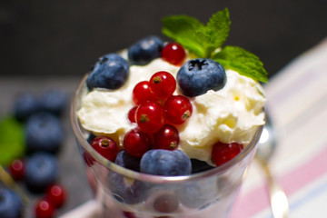 yogurt with currants and blueberries on a dark background