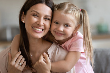 Head shot portrait happy mother piggybacking adorable little daughter