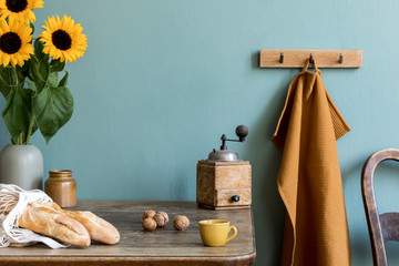 Vintage-Kücheneinrichtung mit Holztisch, Tasche mit Bagels, Sonnenblumen in Vase, Tasse Kaffee und Küchenzubehör. Minimalistisches Konzept des Küchenraums. Landstimmung. Schablone.