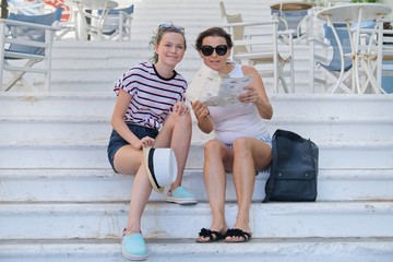 Obraz premium Summer vacation together mother and daughter traveling reading tourist map