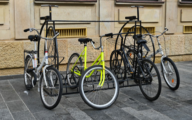 Fototapeta na wymiar Old Fashioned Bike Bike Rack with Bicycles on Gray Block Pavement in Bratislava Slavakia