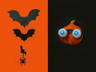 Flat lay Halloween background with pumpkin in in glasses horror symbol eyeball, spider and bats on...