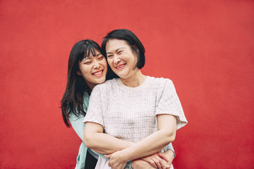 Happy Asian mother and daughter having fun outdoor - Chinese family people spending time together...