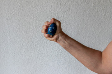 Stressabbau mit Anti-Stressball baut Stress ab durch drücken und quetschen eines blauen Balls mit...
