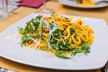 Italian pasta with vegetables, pumpkin and arugula, close up shot