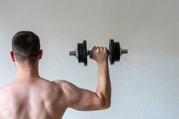 Naklejka na ściany i meble Sportler mit muskulöser Schulter und muskulösem Arm hält Kurzhantel in der rechten Hand für Fitness, Training, Bodybuilding und Kraftsport für Gesundheit und Stärke