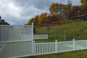 Beautiful view of backyards of townhouses. Autumn colored red and yellow trees on cloudy sky background. 